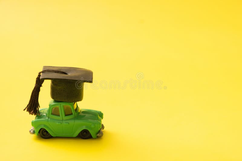 Toy Mini Car With A Graduated Cap Driving Leaning Concept Stock Photo toy-mini-car-with-a-graduated-cap-driving-leaning-concept-stock-photo