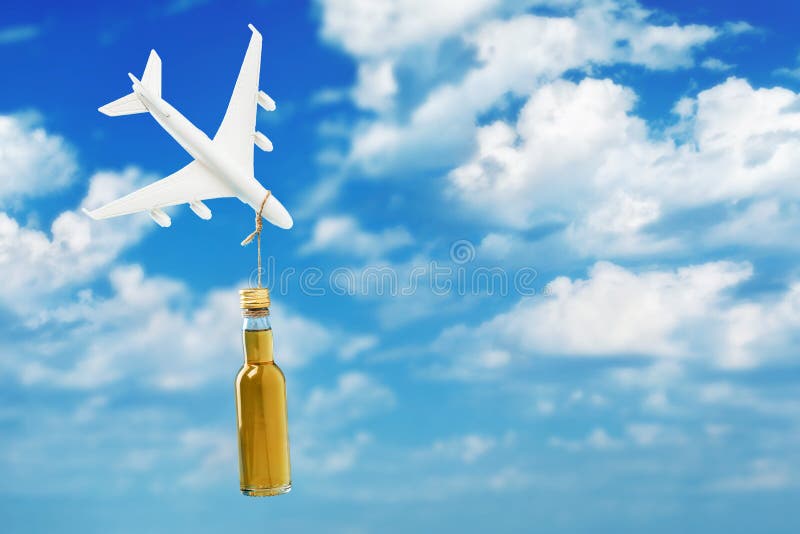 Toy plane and a bottle of whiskey on a background of sky with clouds. Concept on the topic of alcohol abuse on board an airplane