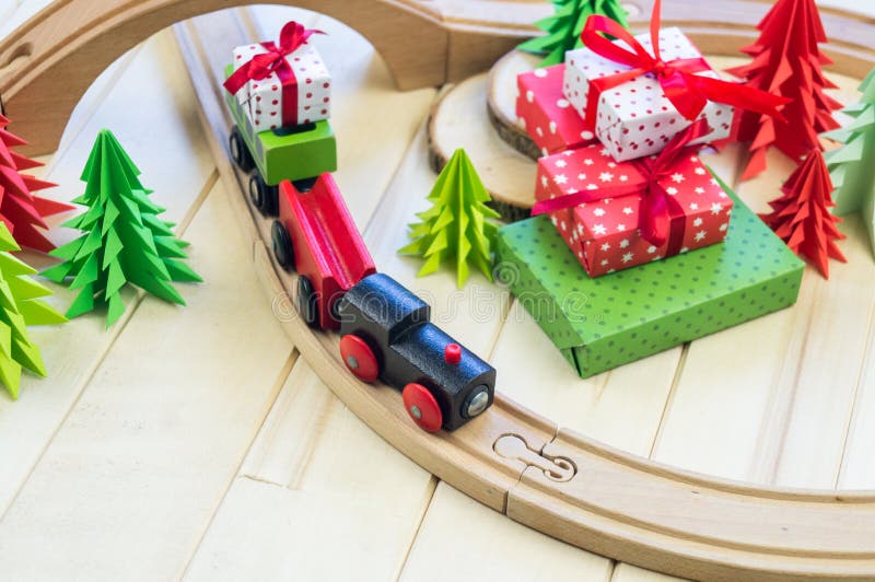 Toy wooden train carries a box with gift the child. Craft, present.
