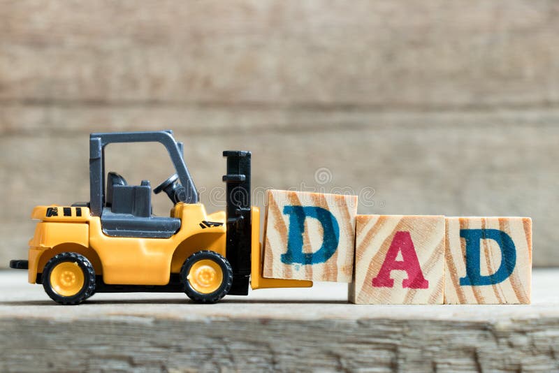 Toy yellow forklift hold letter block D to complete word dad on wood background &#x28;Concept of father day