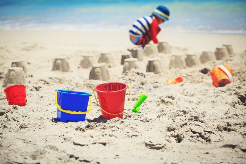 Toys and Little Boy Making Castle on Beach Stock Photo - Image of ...