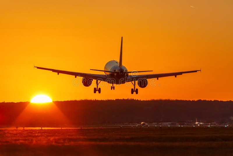 Tra di feste di vacanza di tramonto del sole dell'aeroporto di volo di atterraggio di aeroplano immagine stock libera da diritti Tra di feste di vacanza di tramonto del sole dell'aeroporto di volo di atterraggio di aeroplano immagine stock libera da diritti