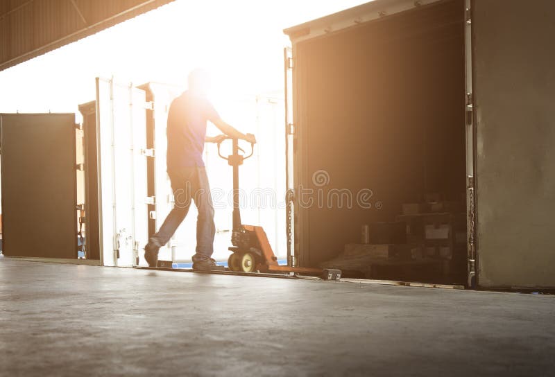 Trabajador de almacén descargando cajas de paquetes fuera del contenedor de carga interior. carga de camiones estacionados en el a