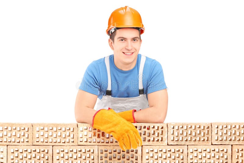 Trabajador de construcción de sexo masculino que descansa sobre una pared de ladrillo foto de archivo libre de regalías Trabajador de construcción de sexo masculino que descansa sobre una pared de ladrillo foto de archivo libre de regalías