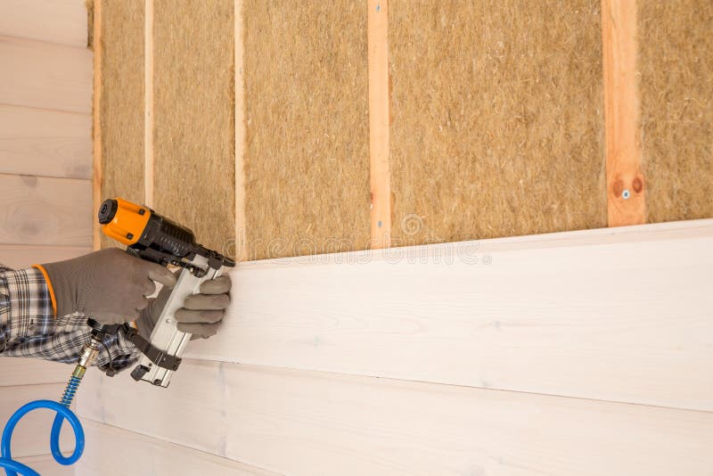 Trabajador de construcción que aísla termalmente la casa de marco de madera del eco foto de archivo libre de regalías Trabajador de construcción que aísla termalmente la casa de marco de madera del eco foto de archivo libre de regalías
