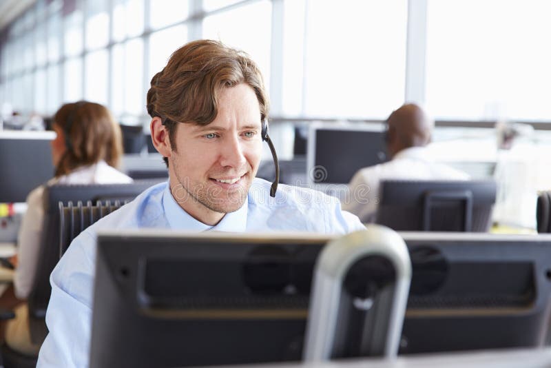 Trabajador de sexo masculino del centro de llamada, mirando la pantalla, primer imagenes de archivo Trabajador de sexo masculino del centro de llamada, mirando la pantalla, primer imagenes de archivo