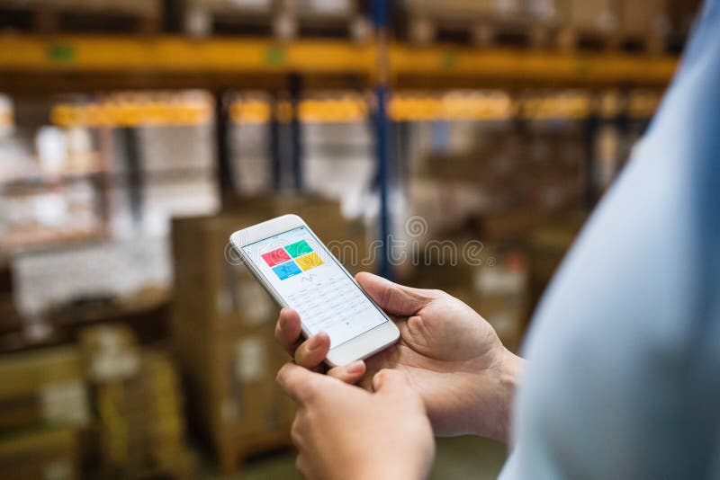 Trabajador del almacén del hombre con un smartphone fotografía de archivo libre de regalías Trabajador del almacén del hombre con un smartphone fotografía de archivo libre de regalías