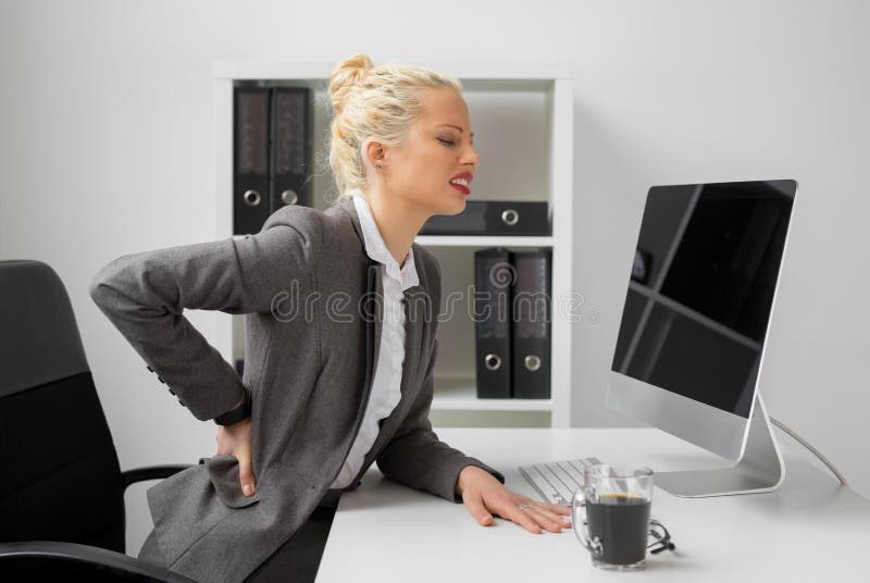 Trabajador en la oficina con dolor de espalda terrible imagenes de archivo Trabajador en la oficina con dolor de espalda terrible imagenes de archivo