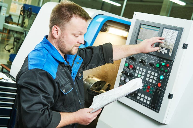 Trabajador industrial que actúa torno del CNC en industria que trabaja a máquina del metal fotografía de archivo Trabajador industrial que actúa torno del CNC en industria que trabaja a máquina del metal fotografía de archivo