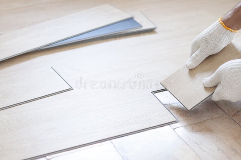 Hand worker installing wood laminate vinyl floor. Oak wood laminate for renovate room. Home. Home renovate and wood materials.  Materials design for home furniture. Copyspace for text background. sample of wood plank surface. Plywood, Laminate, veneer. vinyl wood floor Installation for home decoration with laminate vinyl wood floor. Hand worker installing wood laminate vinyl floor. Oak wood laminate for renovate room. Home. Home renovate and wood materials.  Materials design for home furniture. Copyspace for text background. sample of wood plank surface. Plywood, Laminate, veneer. vinyl wood floor Installation for home decoration with laminate vinyl wood floor