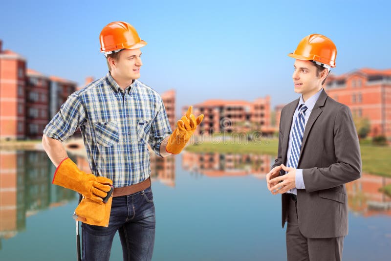 Trabajador manual de sexo masculino que tiene una conversación con el arquitecto, constru imagen de archivo Trabajador manual de sexo masculino que tiene una conversación con el arquitecto, constru imagen de archivo