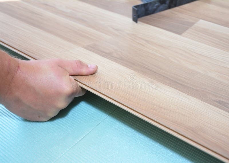 Trabajador que instala el suelo laminado de madera fotos de archivo Trabajador que instala el suelo laminado de madera fotos de archivo