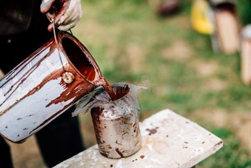 trabajador que lleva los guantes protectores que vierten la pintura líquida en el arma de espray para pintar pedazos de madera foto de archivo libre de regalías trabajador que lleva los guantes protectores que vierten la pintura líquida en el arma de espray para pintar pedazos de madera foto de archivo libre de regalías