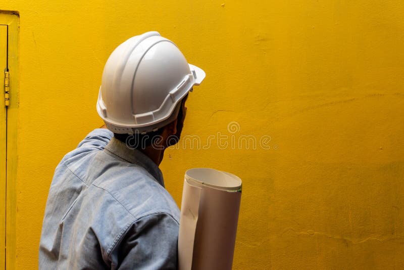 Trabajador que mantiene al constructor del plan de inicio mientras espera el futuro foto de archivo libre de regalías