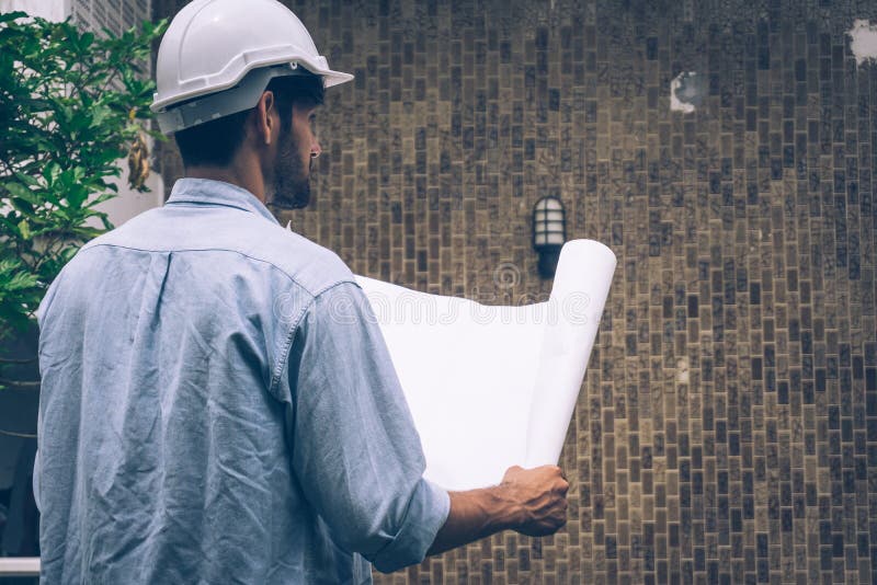 Trabajador que mantiene al constructor del plan de inicio mientras espera el futuro imagen de archivo