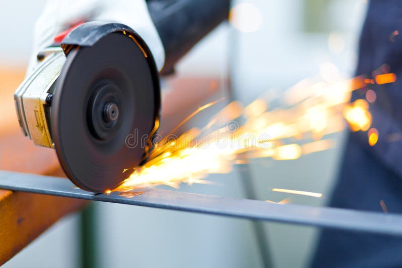 Trabajador que muele una placa de metal fotografía de archivo Trabajador que muele una placa de metal fotografía de archivo