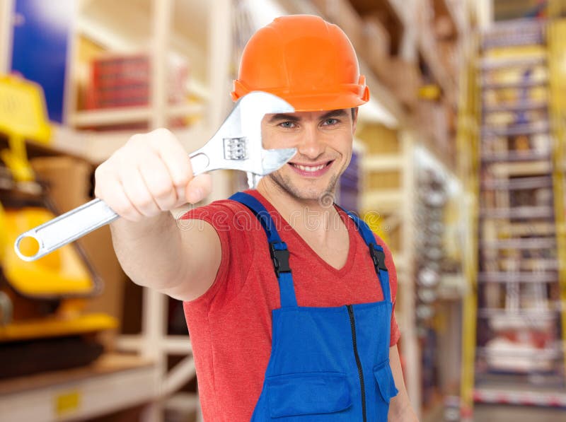 Trabajador sonriente con la llave inglesa grande imagen de archivo