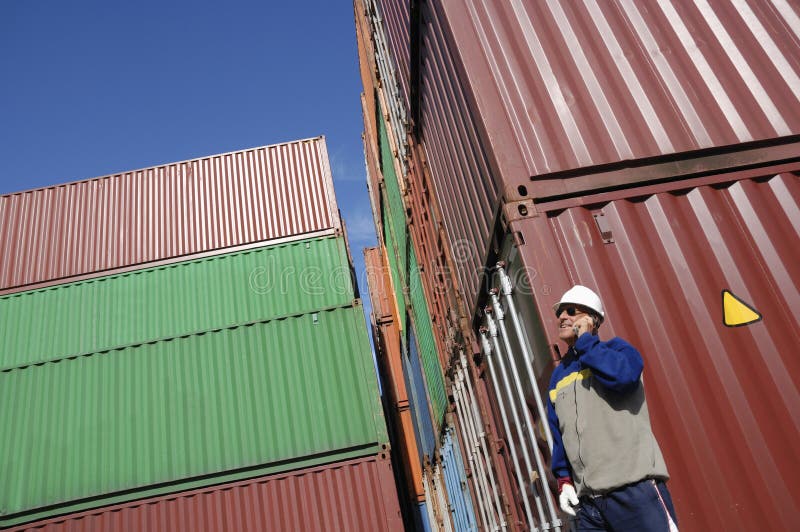 Trabajador y envases de muelle imagen de archivo libre de regalías Trabajador y envases de muelle imagen de archivo libre de regalías