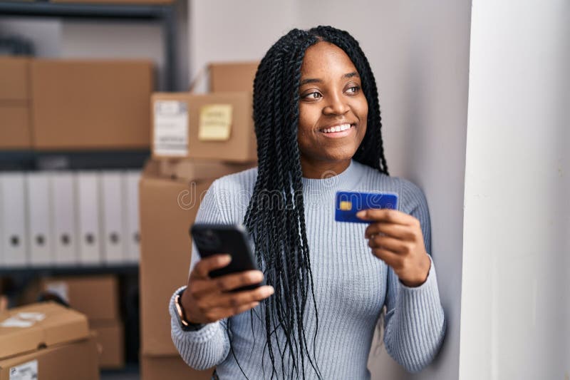Trabajadora de negocios de ecommerce de áfrica con smartphone y tarjeta de crédito en la oficina foto de archivo libre de regalías
