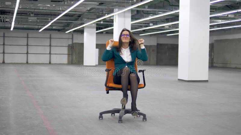 Trabajadora divirtiÃ©ndose, montando una silla de oficina