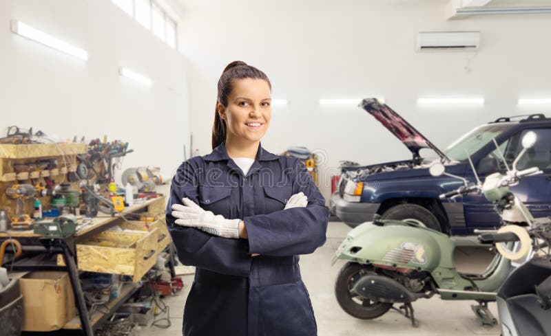 Trabajadora mecánica femenina joven con uniforme y guantes generales fotos de archivo