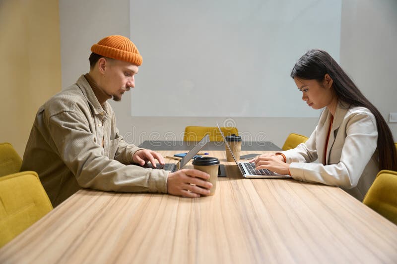 Trabajadores de oficina que trabajan en laptops en sala de reuniones foto de archivo libre de regalías