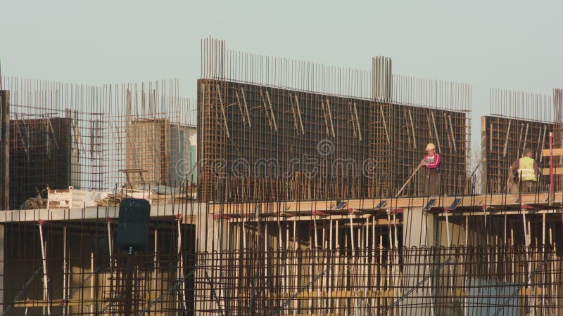 Trabajadores del emplazamiento de la obra en el trabajo fotos de archivo libres de regalías Trabajadores del emplazamiento de la obra en el trabajo fotos de archivo libres de regalías