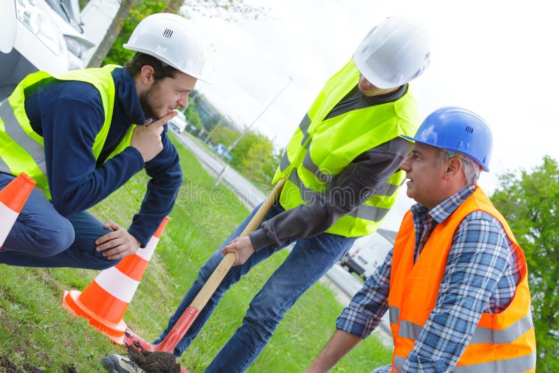 Trabajadores del grupo con las palas que cavan el foso fotos de archivo libres de regalías Trabajadores del grupo con las palas que cavan el foso fotos de archivo libres de regalías