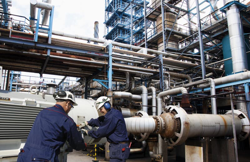 Trabajadores del petróleo y gas dentro de la industria grande de la refinería fotografía de archivo libre de regalías Trabajadores del petróleo y gas dentro de la industria grande de la refinería fotografía de archivo libre de regalías