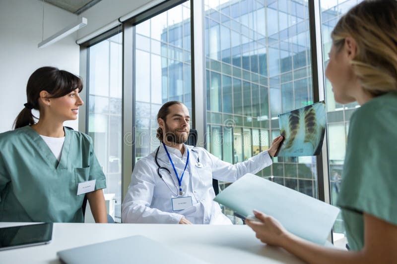 Trabajadores médicos en la clínica estudiando la imagen de rayos X y hablando fotografía de archivo