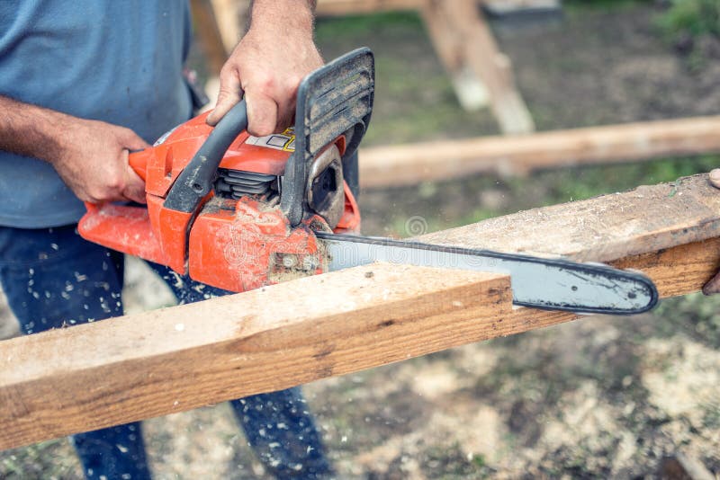 Trabajadores que usan una madera industrial de la construcción del corte y del sawing de la motosierra Trabajador que corta la ma foto de archivo Trabajadores que usan una madera industrial de la construcción del corte y del sawing de la motosierra Trabajador que corta la ma foto de archivo