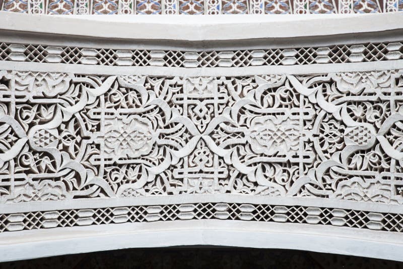 Trabajo complejo marroquí del yeso alrededor de la entrada con símbolos moros tradicionales y detalles árabes fotografía de archivo Trabajo complejo marroquí del yeso alrededor de la entrada con símbolos moros tradicionales y detalles árabes fotografía de archivo