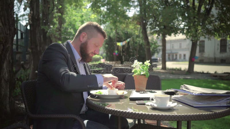 Trabajo del acabamiento del hombre de negocios durante almuerzo outdoor tiro del steadicam