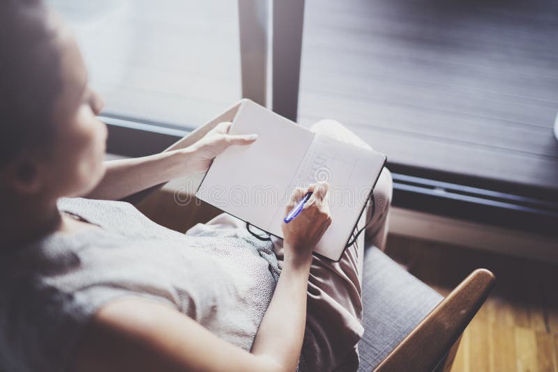 Trabajo en el país de concepto Escritura de la mujer de negocios y notas jovenes el tomar mientras que relaje la sentada en silla imagen de archivo libre de regalías Trabajo en el país de concepto Escritura de la mujer de negocios y notas jovenes el tomar mientras que relaje la sentada en silla imagen de archivo libre de regalías