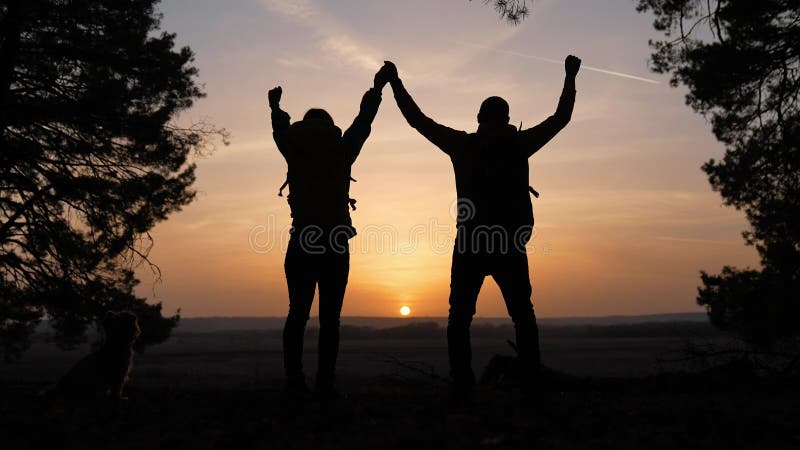 Trabajo en equipo. negocio un concepto de viaje. feliz equipo de turistas hombre y mujer la silueta de la puesta de sol entrega tr