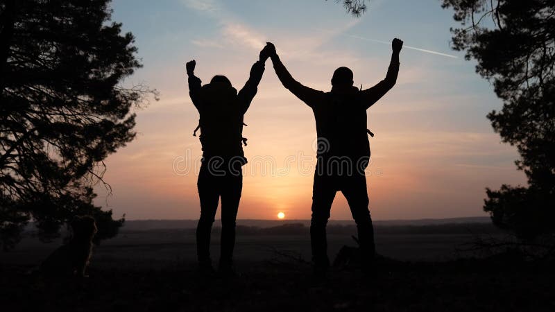 Trabajo en equipo. negocio un concepto de viaje. feliz equipo de turistas hombre y mujer la silueta de la puesta de sol entrega tr