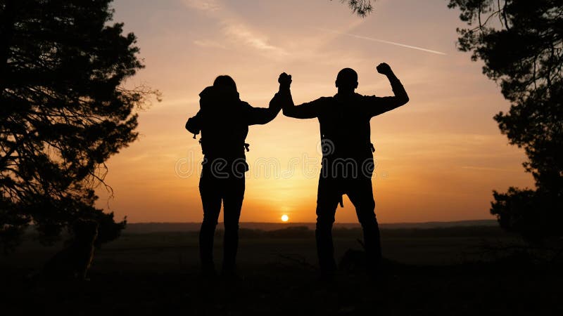 Trabajo en equipo. negocio un viaje concepto ganar. feliz familia equipo turistas hombre y mujer puesta del sol silueta manos arri