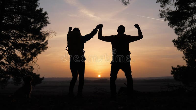 Trabajo en equipo. negocio un viaje concepto ganar. feliz familia equipo turistas hombre y mujer puesta del sol silueta manos arri