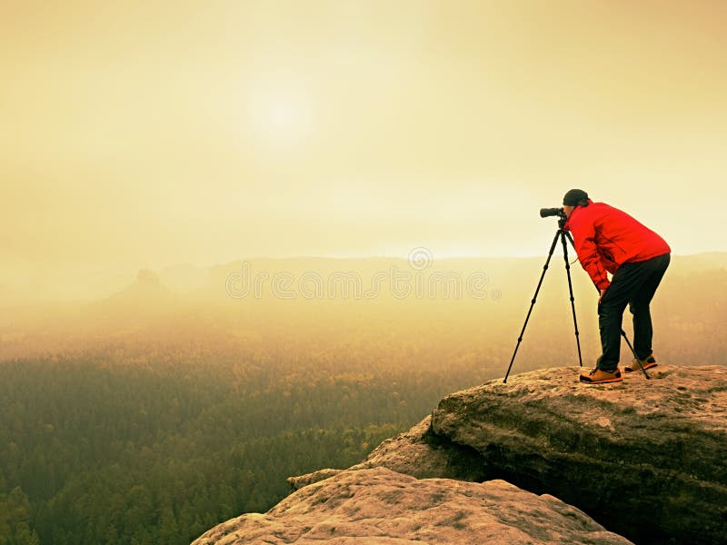 Trabajo profesional del fotógrafo sobre pico de montaña El fotógrafo de la naturaleza toma las fotos con la cámara del espejo en fotografía de archivo libre de regalías Trabajo profesional del fotógrafo sobre pico de montaña El fotógrafo de la naturaleza toma las fotos con la cámara del espejo en fotografía de archivo libre de regalías