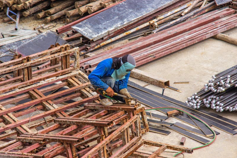 Trabalhador de solda industrial para a construção da fundição de aço na construção da área com processo de solda pela soldadura d fotografia de stock royalty free Trabalhador de solda industrial para a construção da fundição de aço na construção da área com processo de solda pela soldadura d fotografia de stock royalty free