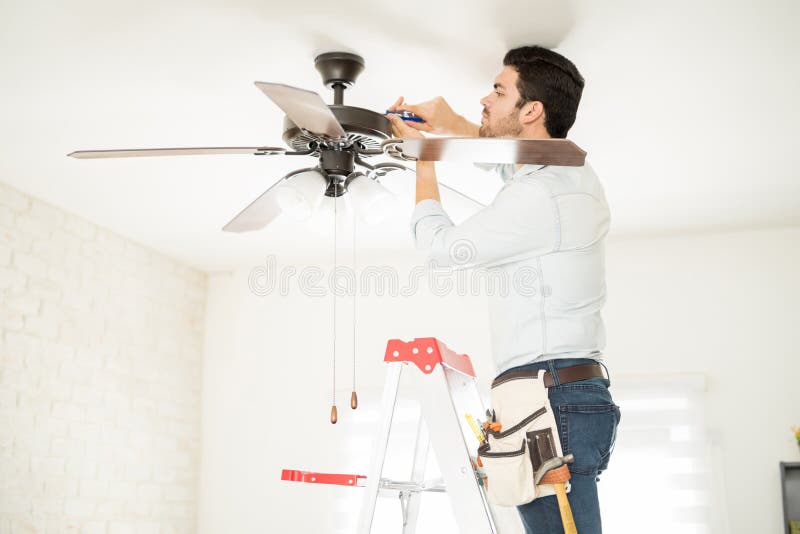 Trabalhador manual que instala um fã de teto