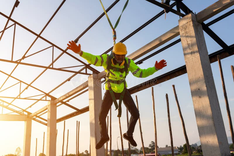 Construction workers fall from a height but have safety to help. Concept of preventing danger from heights with Safety on the construction site. Construction workers fall from a height but have safety to help. Concept of preventing danger from heights with Safety on the construction site.