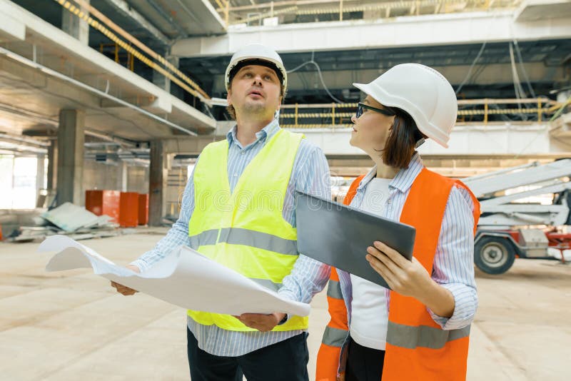 Trabalhadores de construção que trabalham no canteiro de obras, construtores que olham no modelo Conceito da construção, do desen fotografia de stock Trabalhadores de construção que trabalham no canteiro de obras, construtores que olham no modelo Conceito da construção, do desen fotografia de stock