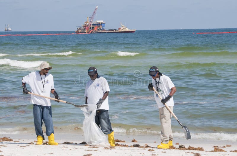 Trabalhadores do derramamento de petróleo no seashore fotografia de stock royalty free Trabalhadores do derramamento de petróleo no seashore fotografia de stock royalty free