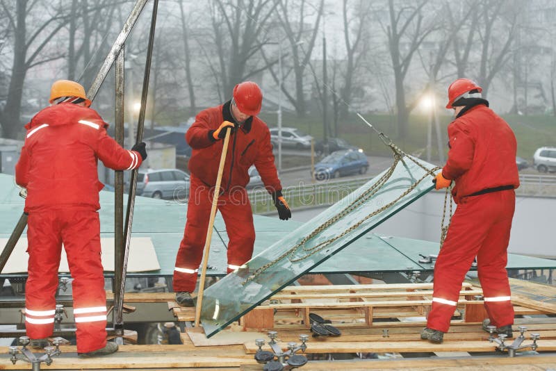 Trabalhadores que instalam o indicador de vidro na construção