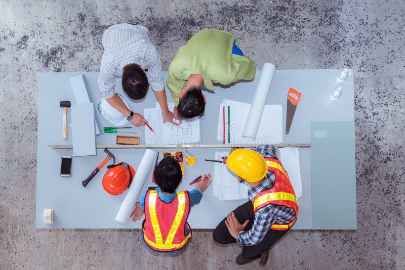 Trabalho da equipe da construção, eles ` com referência à fala sobre o projeto novo, v superior Trabalho da equipe da construção, eles ` com referência à fala sobre o projeto novo, v superior