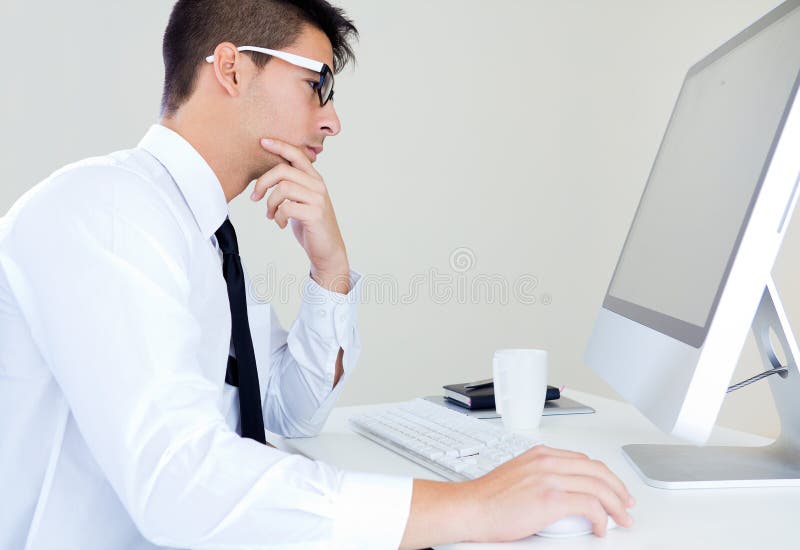 Trabalho novo do homem de negócio no escritório moderno no computador imagem de stock royalty free Trabalho novo do homem de negócio no escritório moderno no computador imagem de stock royalty free