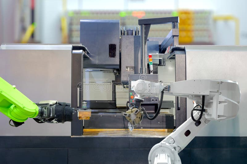 Trabalhos de equipe industriais da robótica no trabalho com a máquina do torno do CNC Trabalhos de equipe industriais da robótica no trabalho com a máquina do torno do CNC