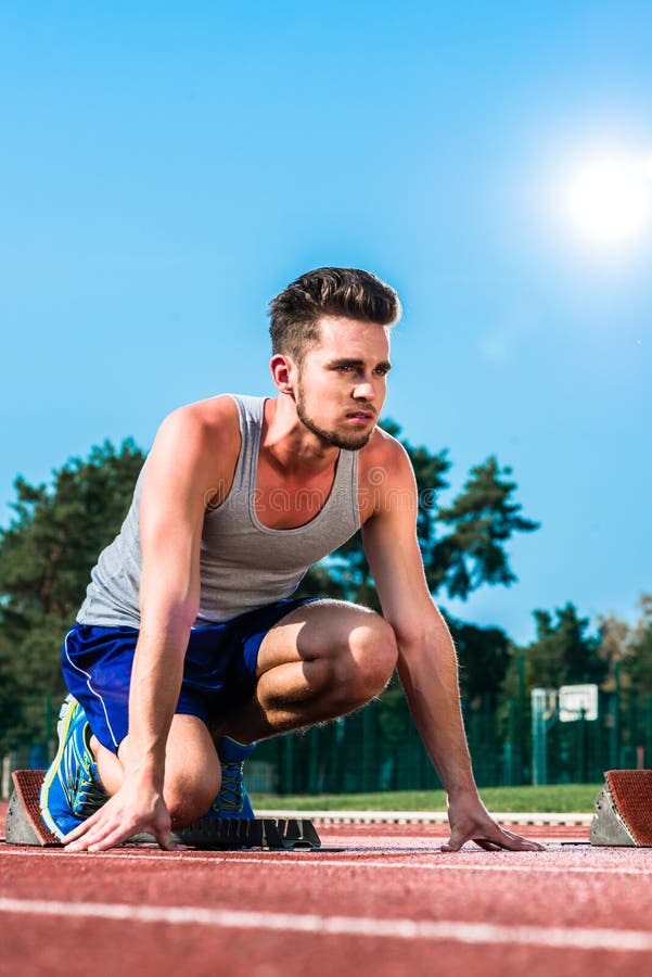 Track And Field Sprinter On Starting Point At Cinder Track In Sp