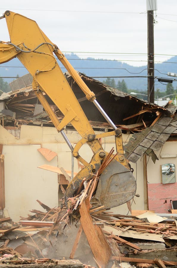A large track hoe excavator tearing down an old hotel to make way for a new commercial development. Track hoe construction excavator stock images, royalty-free photos and pictures